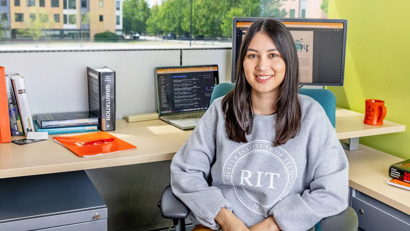 An R I T student sitting at a desk in the Center for Computational Relativity and Gravitation.