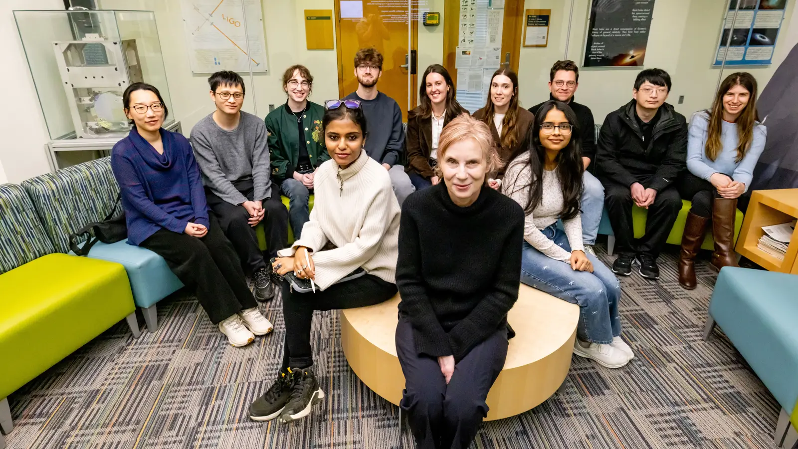 Manuella Campanelli sits in the middle surrounded by eleven students and staff.