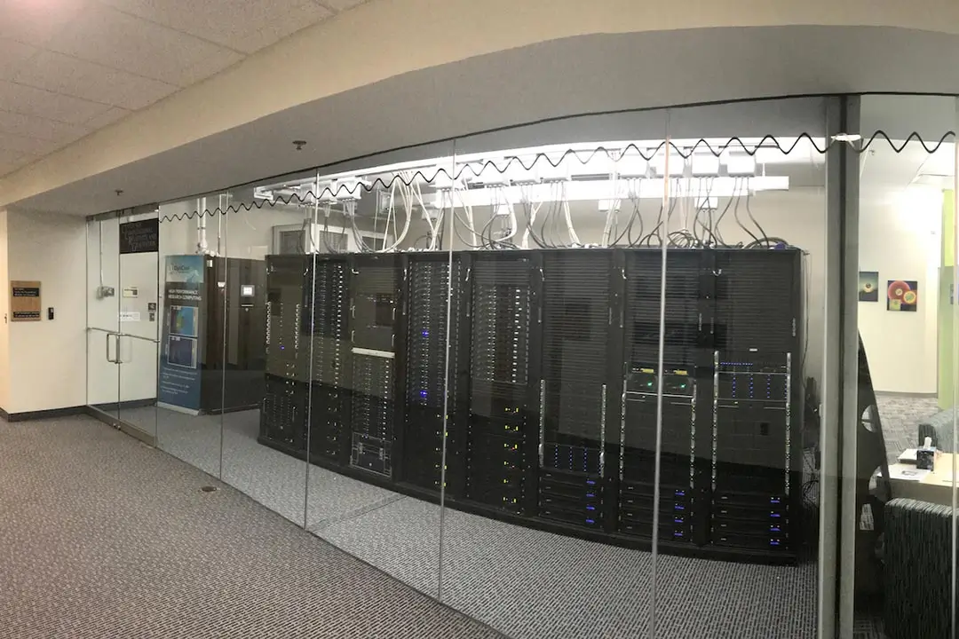 A large server room, with one wall made entirely of glass.