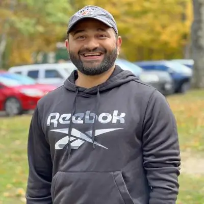 Muhammad Zeeshan wearing a hoodie and an R I T hat.