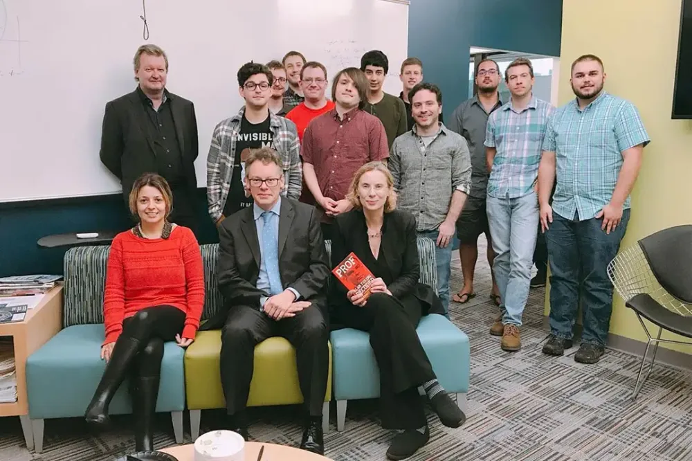 A group of people poses for a photo in a lounge area.