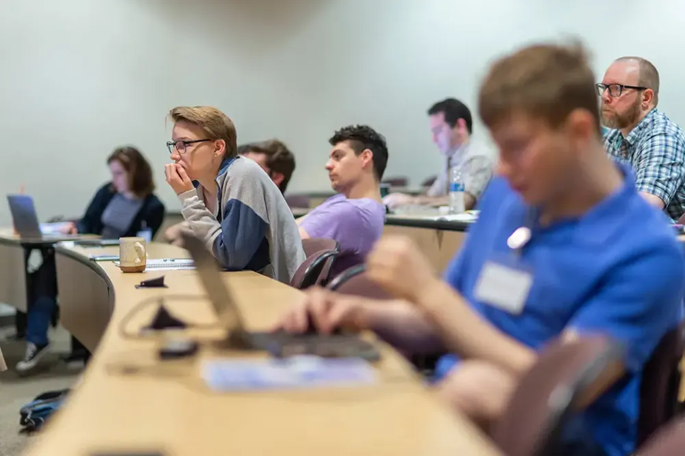 Students in a lecture hall listen intently.