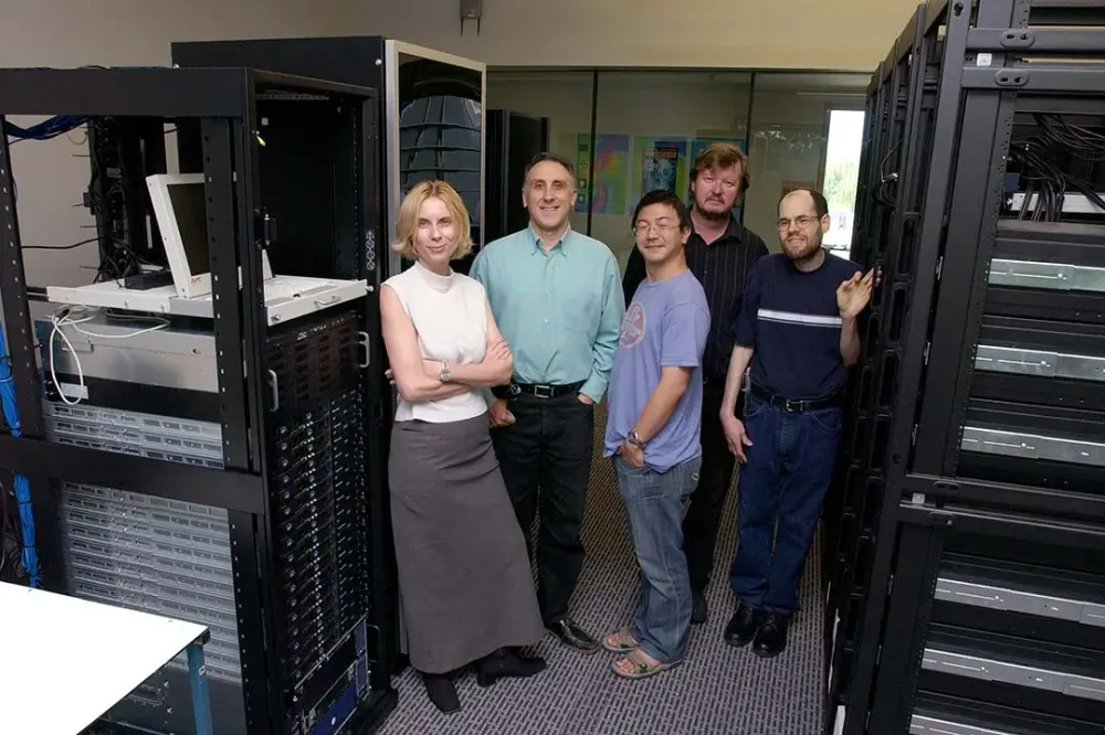 Four researchers pose for a photo in a server room.