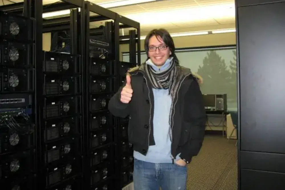A person in the server room gives a thumbs up.