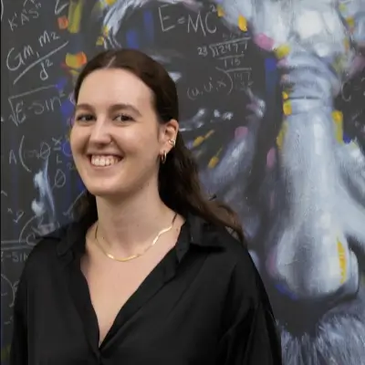 Maria Chiara standing in front of a painting of Albert Einstein.