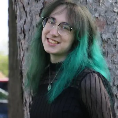 Noelle Feist standing in front of a tree.