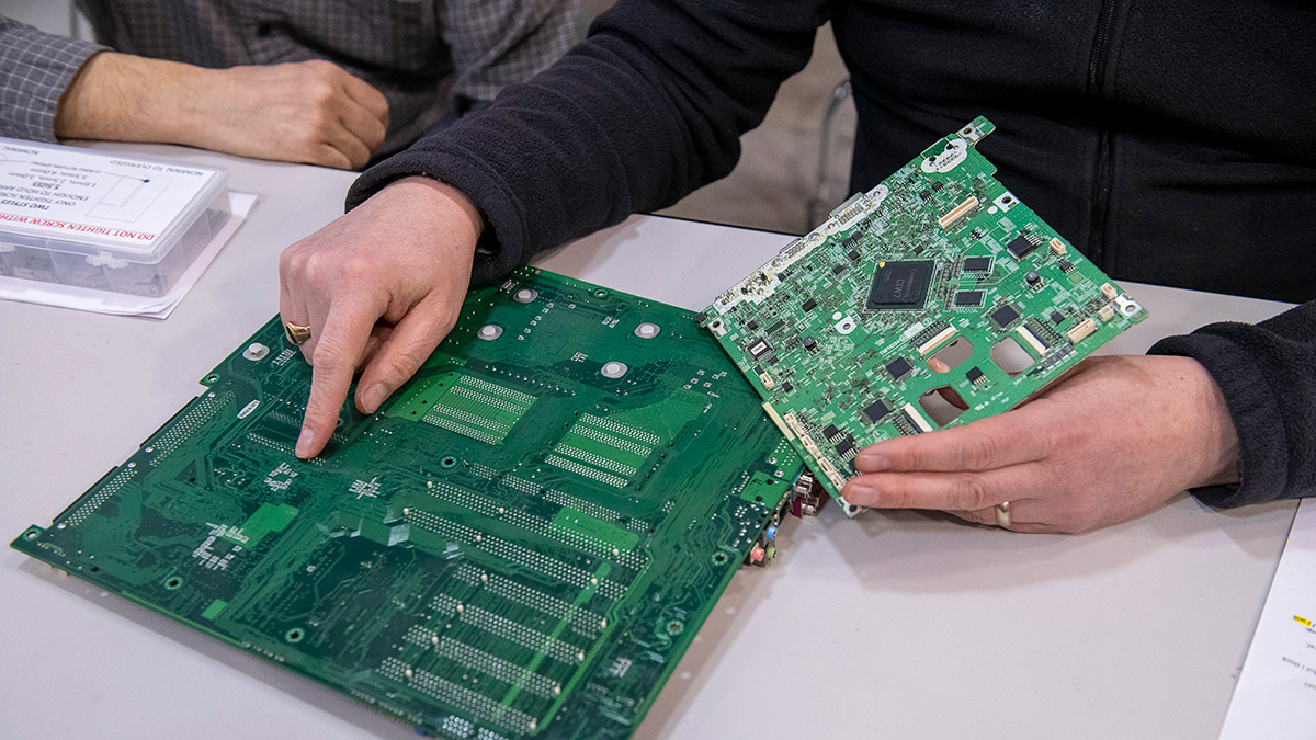 Student pointing at a printed circuit board.