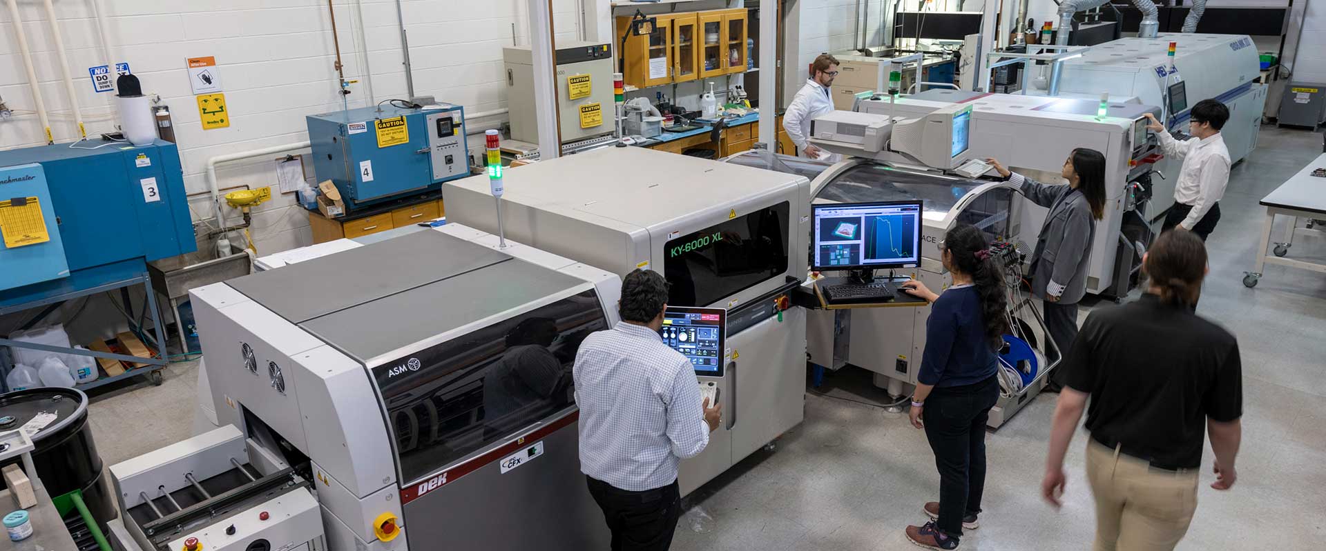 people working with large machinery in a lab.