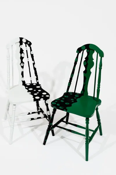2 black mat chairs that are color blocked with green & white dots on them 