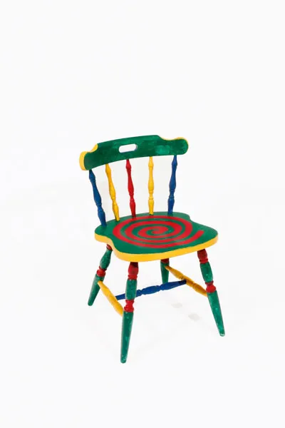 A bright green, red, yellow and blue chair with a red spiral on the seat.