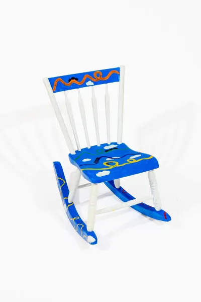 Children's rocking chair painted blue and white with roller coasters and clouds.