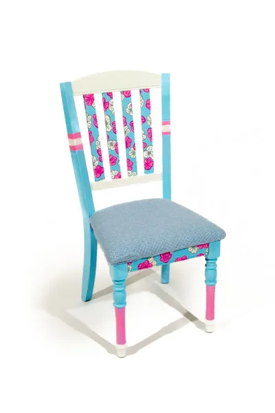 Pastel blue chair, with pink and white flowers, and pink white and blue legs.