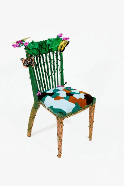 green with brown legs, has purple lilac bunches on top and other greenery, has butterflies and other bugs, seat contains felt clusters of blue, green, and brown