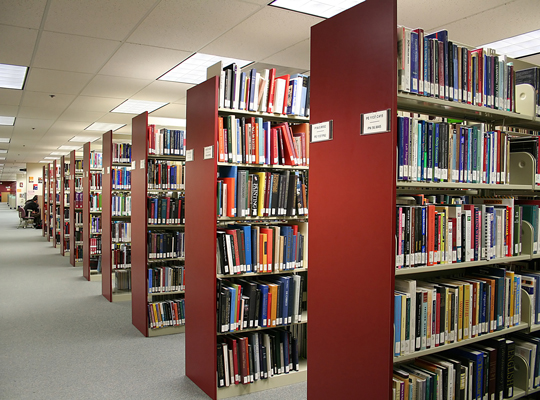 library stacks of books on red shelves