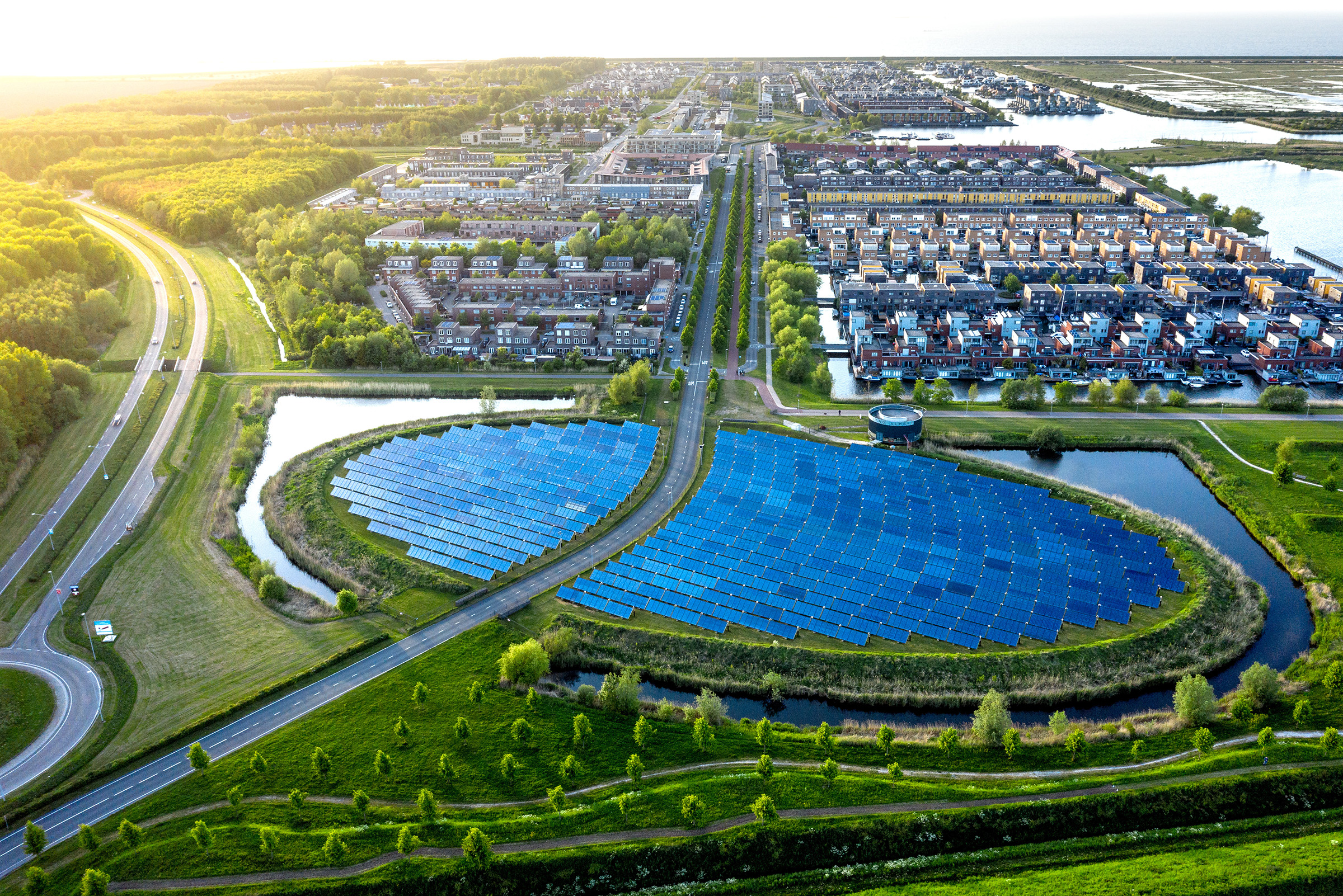 Aerial view of neighborhood powered by solar farm along highway
