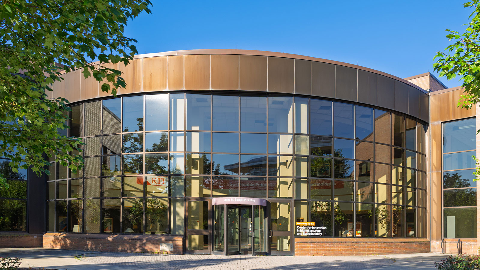 exterior of CIMS building with green trees and blue sky on a bright sunny day