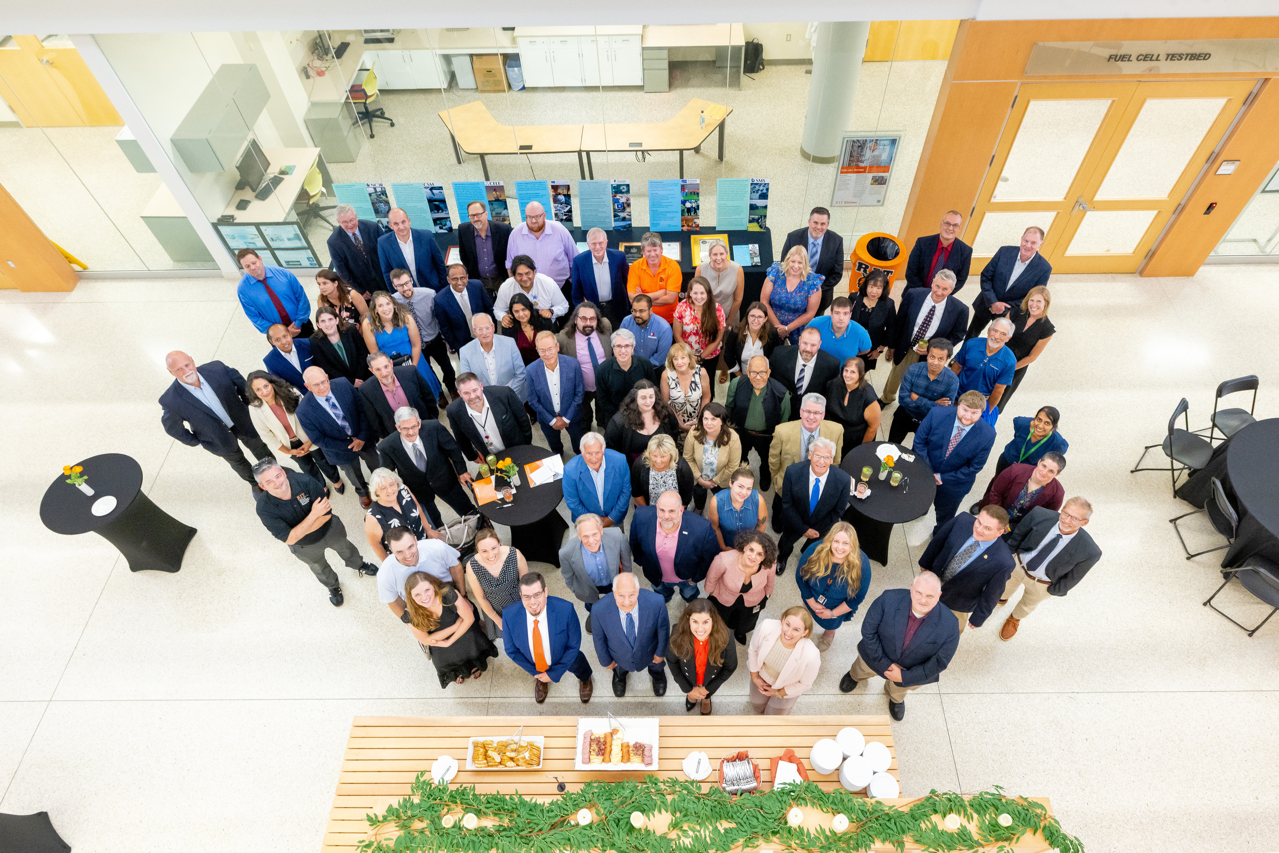group photo from above of many people in business professional attire looking up
