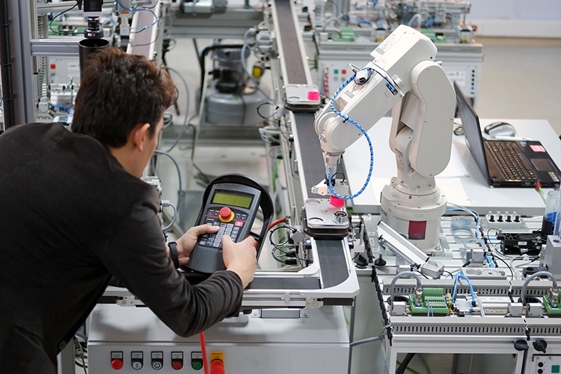 Person controlling robotic arm for manufacturing