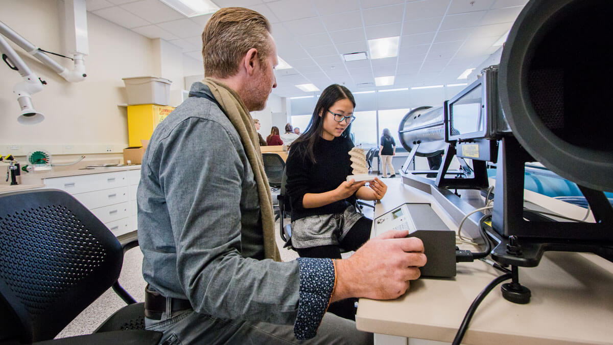 A researcher working with a student in the Sustainable Building Materials Lab.