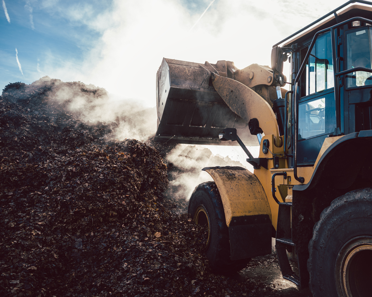 Earth mover working on pile of compost