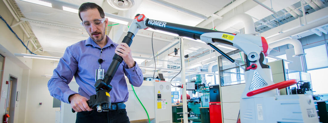 A researcher using the laser arm scanner in a lab