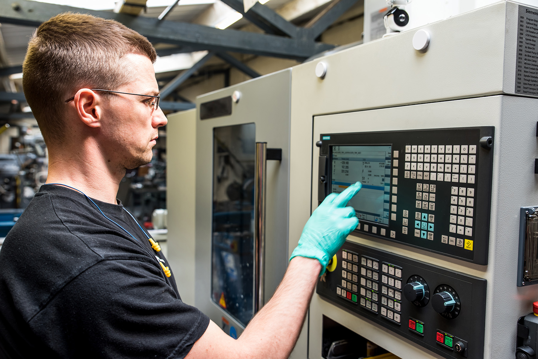 Man pressing buttons in industrial setting