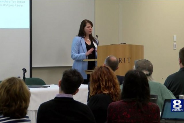 Researcher speaks at podium.
