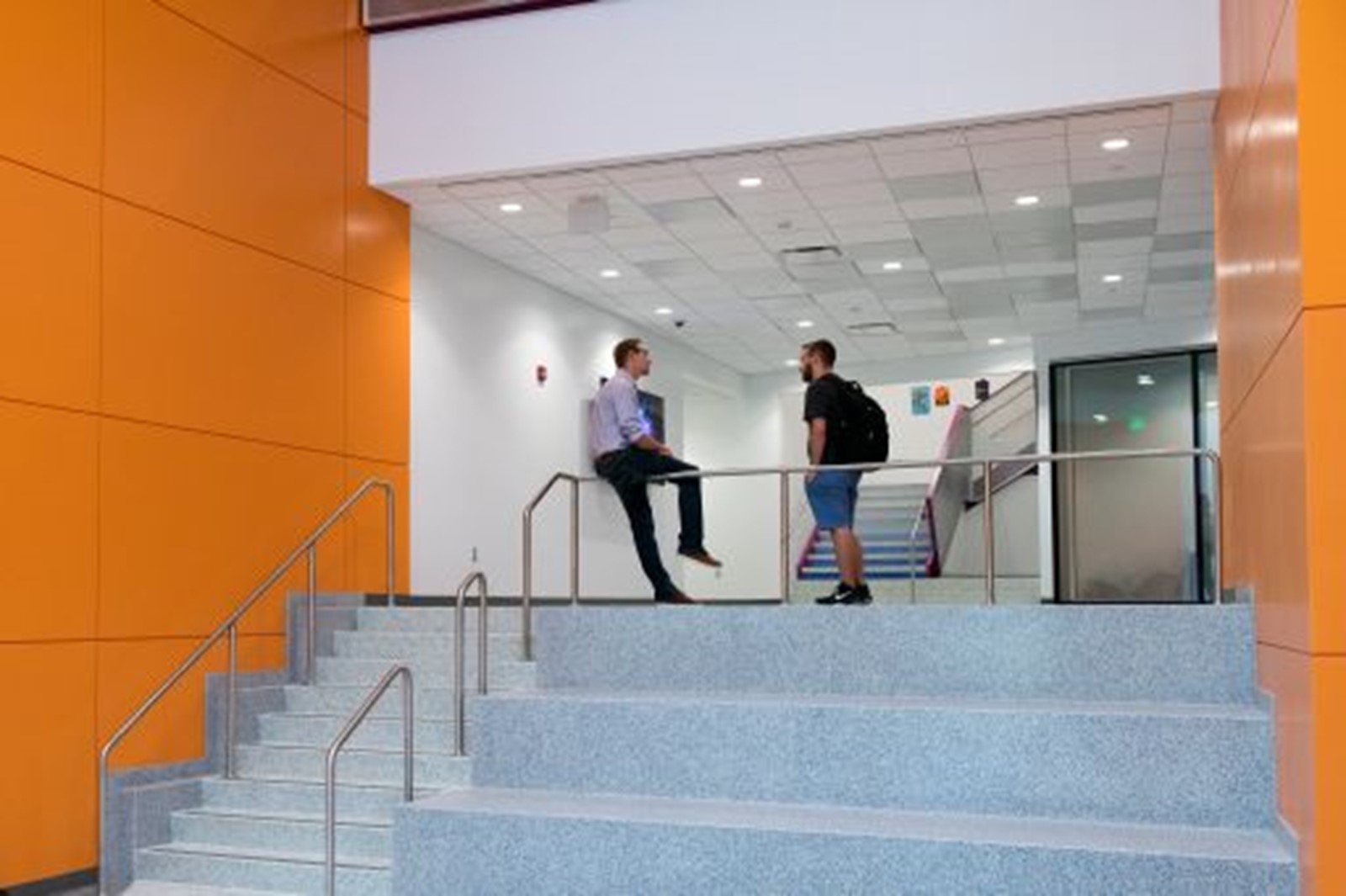 Two people talking on a set of stairs in the MAGIC Center