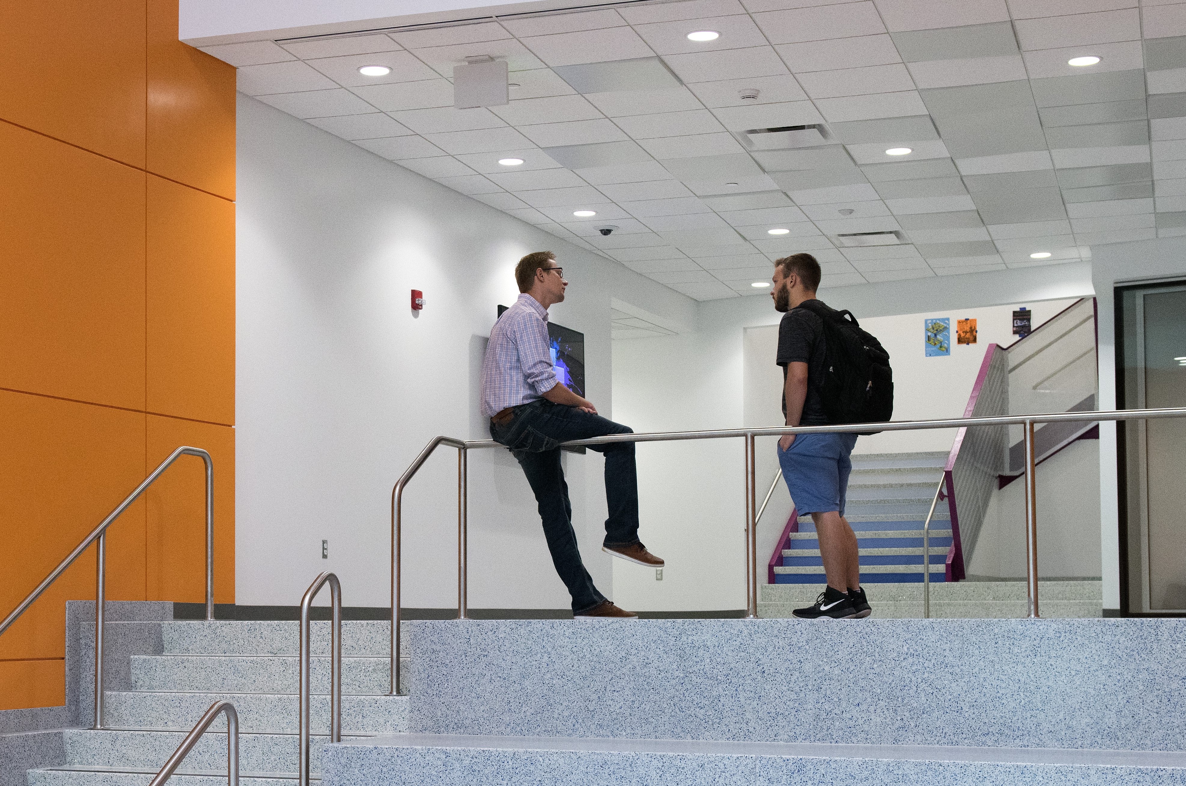 Two people in orange hallway