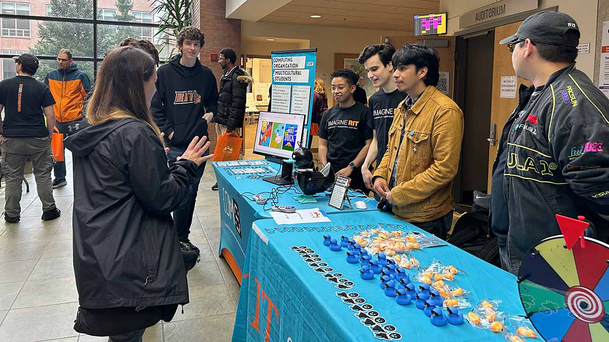 a table display at Imagine R I T promoting the Computing Organization for Multicultural Students.