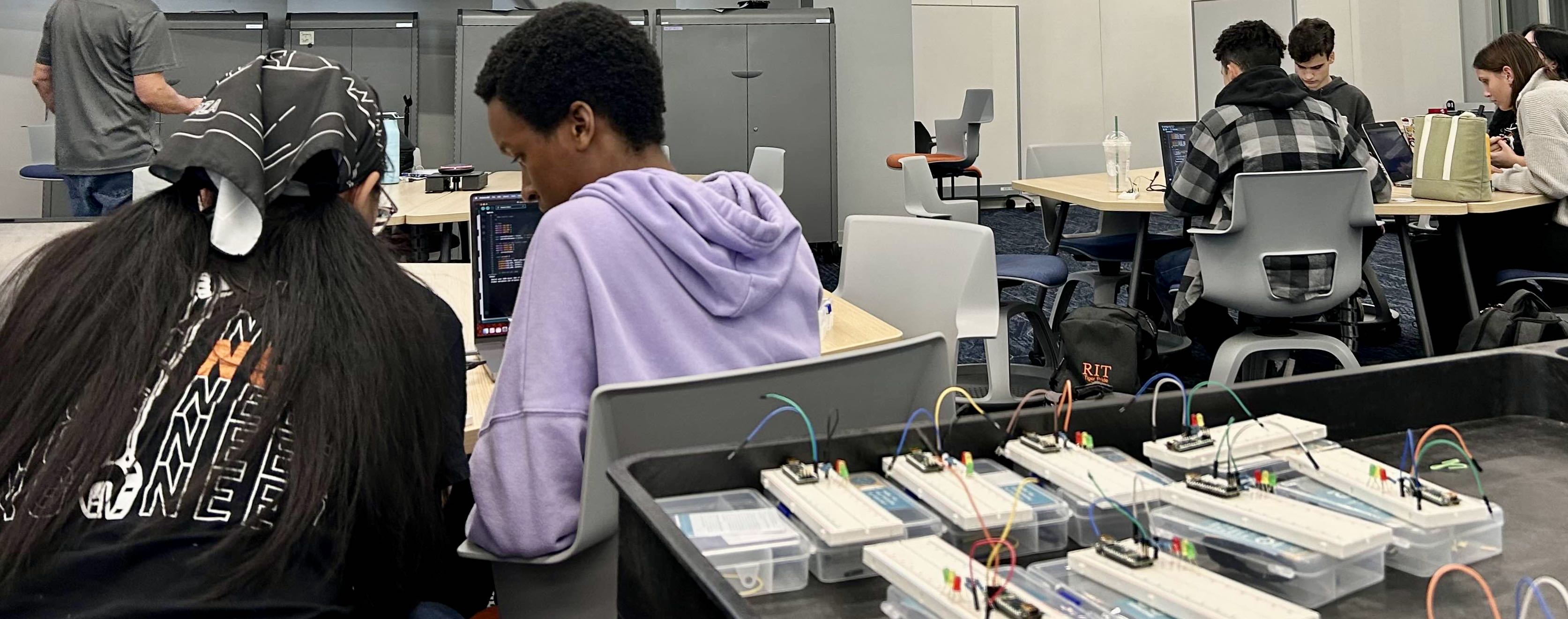 COMS Students working together on arduino hardware kits at an event