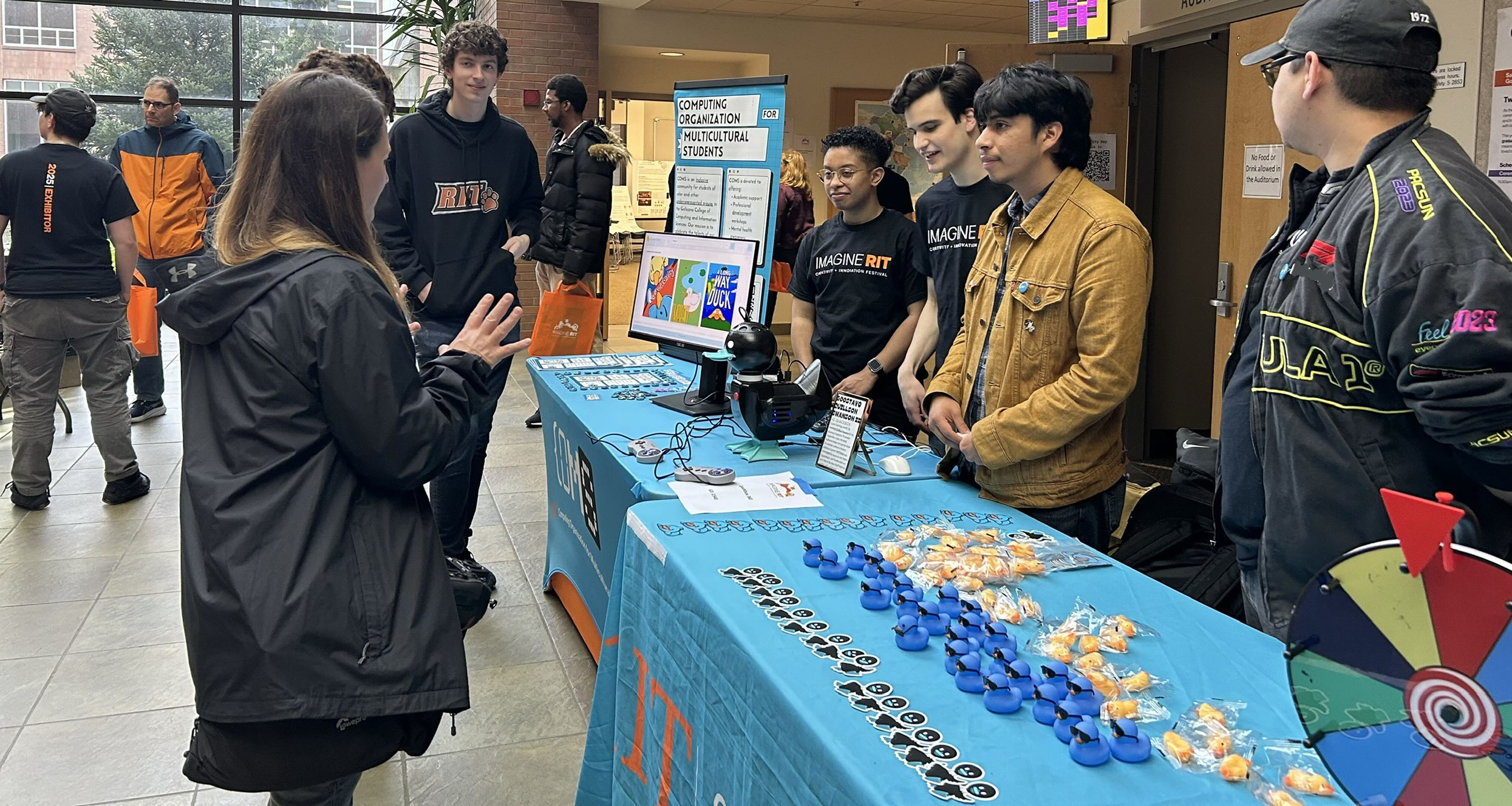 COMS table at Imagine RIT with students collaborating