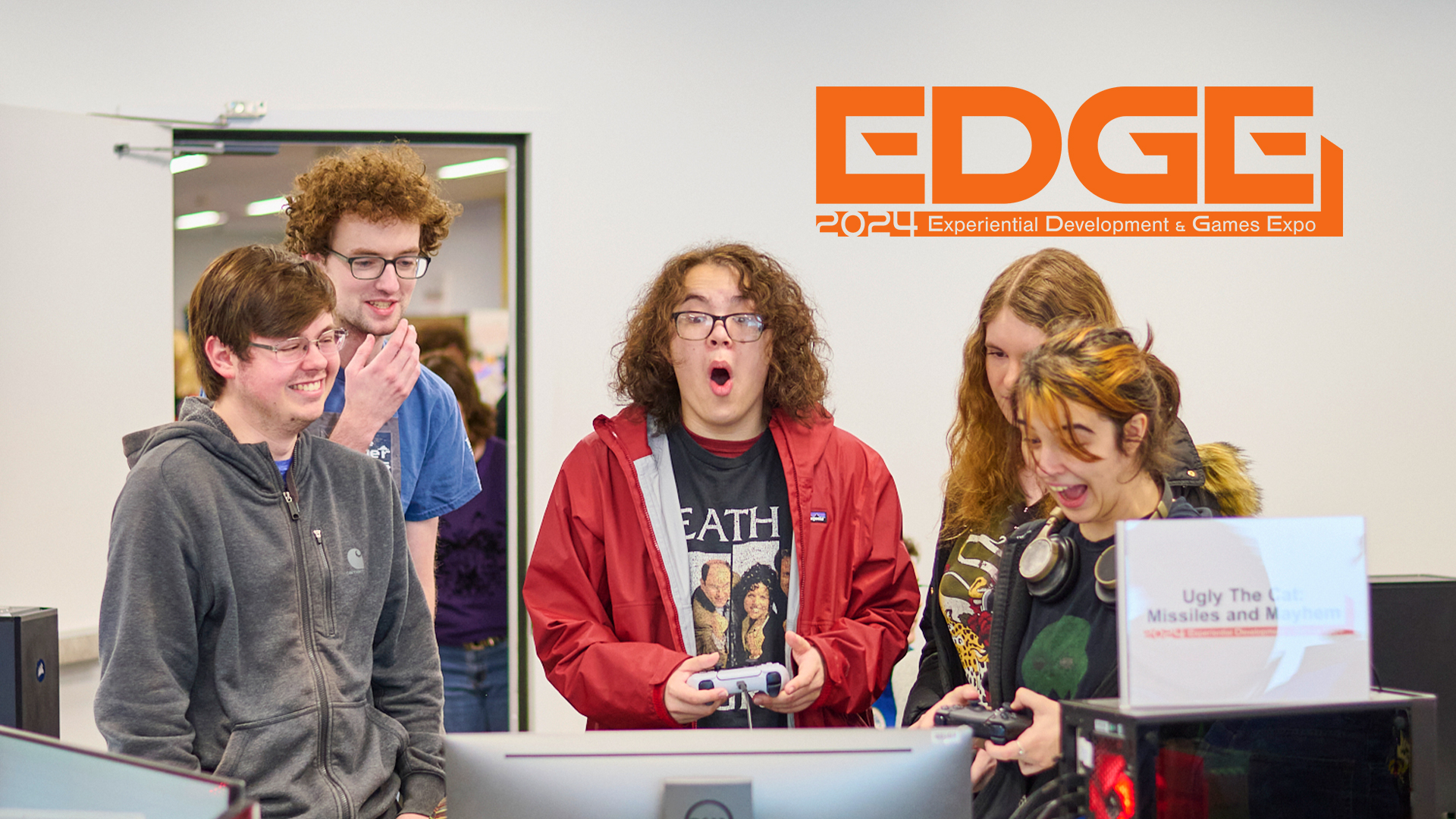 a picture of students smiling excitedly while playing a video game in a computer lab. in the upper right the text reads EDGE 2024