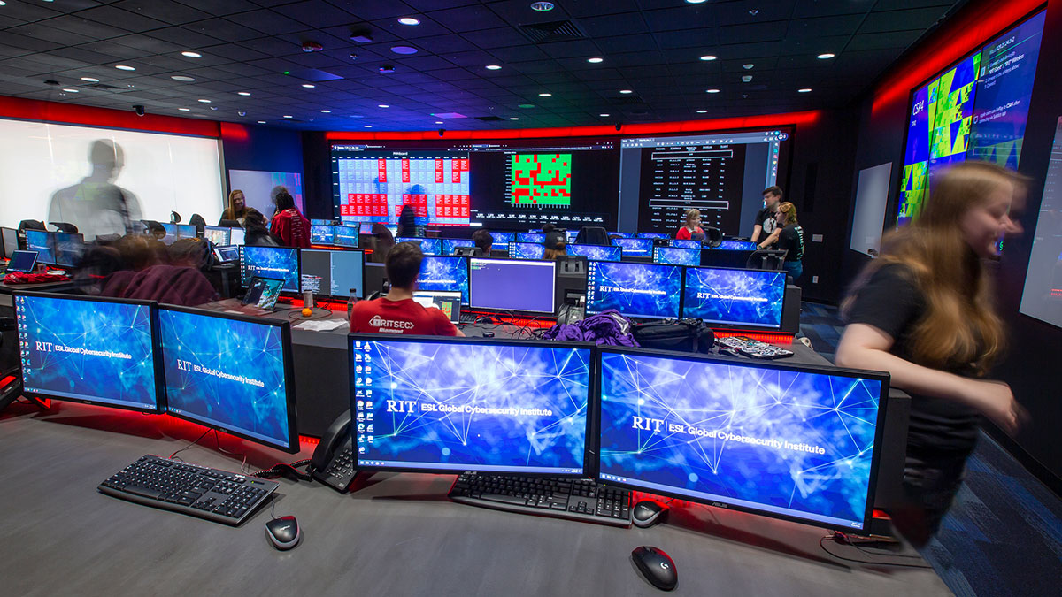 A state-of-the-art cybersecurity lab with multiple computer monitors and digital dashboards displayed.