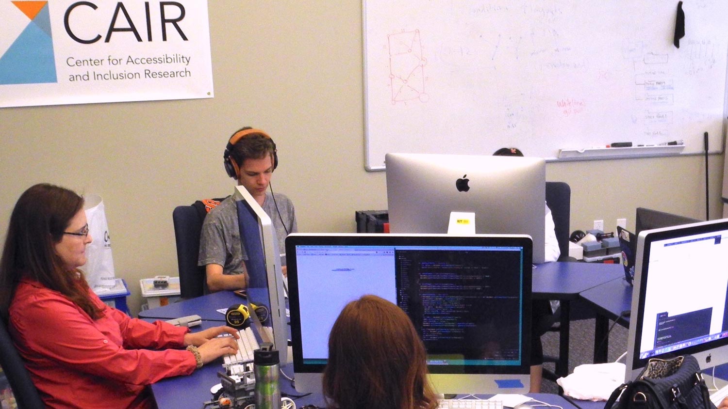 Students working on desktop computers at a desk.