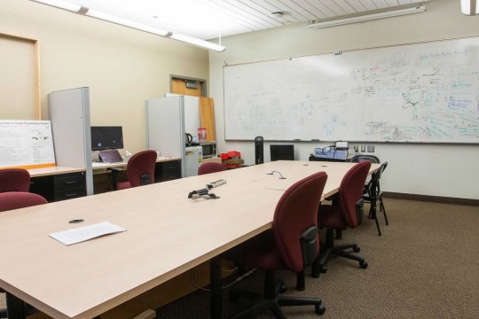 Carpeted room with a large whiteboard and conference table