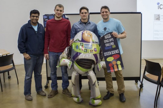 People posing with cardboard figure at event
