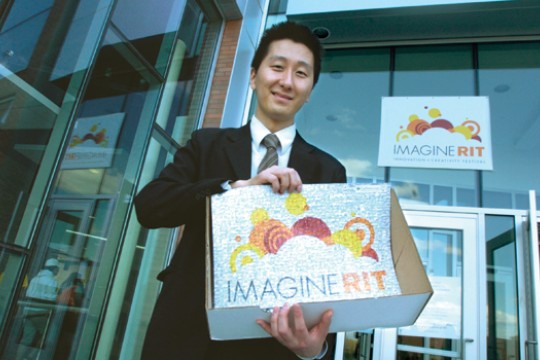Student holding "Imagine RIT" signs