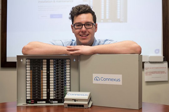 Brandon Hudson standing behind his thermostat system.