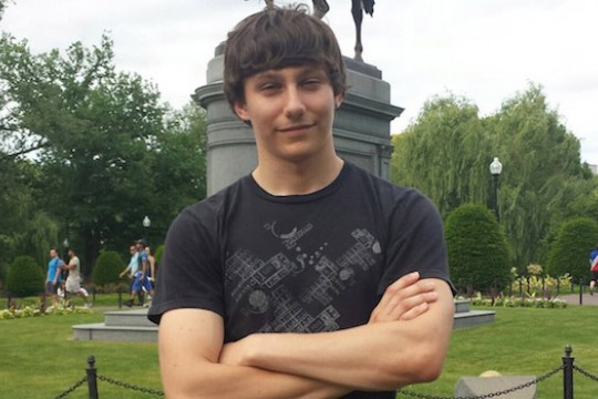 Student posing in front of statue
