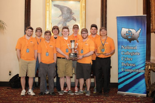 People posing with award at event
