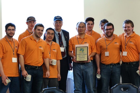 People posing with award at event