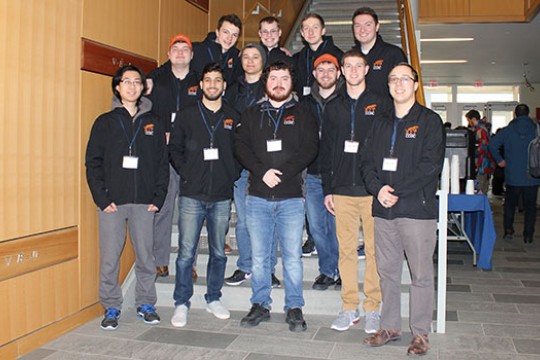 Team of RIT cybersecurity students poses for picture in front of staircase.