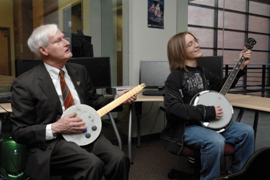 RIT president and student playing instruments