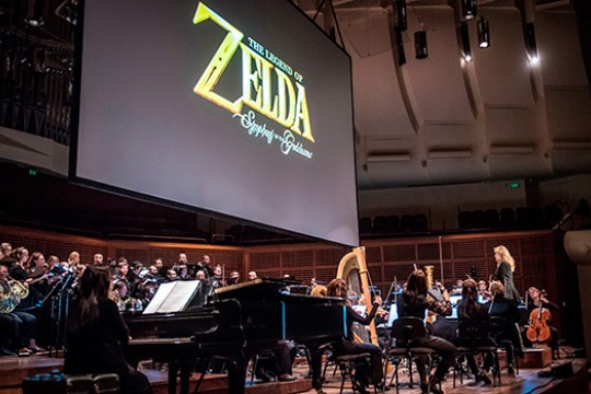 Musicians performing on stage with Legend of Zelda logo