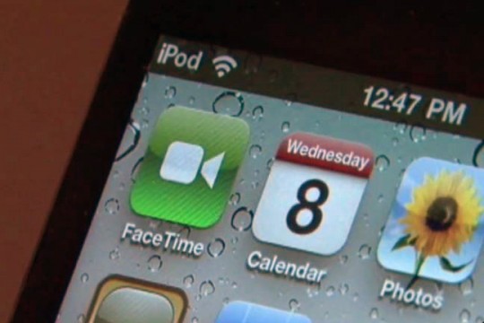 Close-up of iPhone screen showing the Facetime, Calendar and Photos app icons