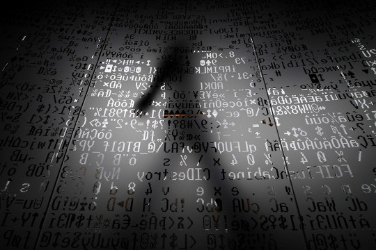 Graphic of shadow of person walking by overlay of HTML code