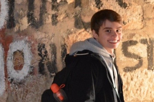 Student next to brick wall