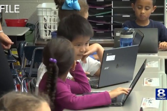 two children looking at a laptop computer.