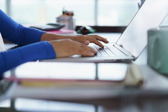 user typing on laptop.